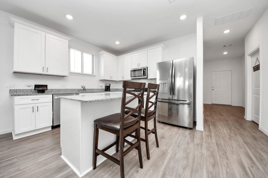 Greeted by open floor plan kitchen/dining/living area