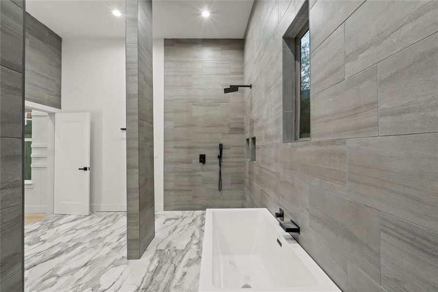 Bathroom featuring independent shower and bath, tile patterned flooring, and tile walls