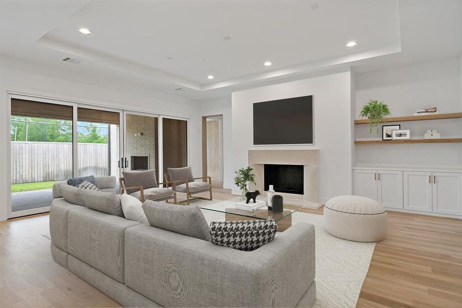 A look at the living room and its fireplace, built in shelving & cabinets and access to the covered back patio through massive sliding doors. *Virtually Staged