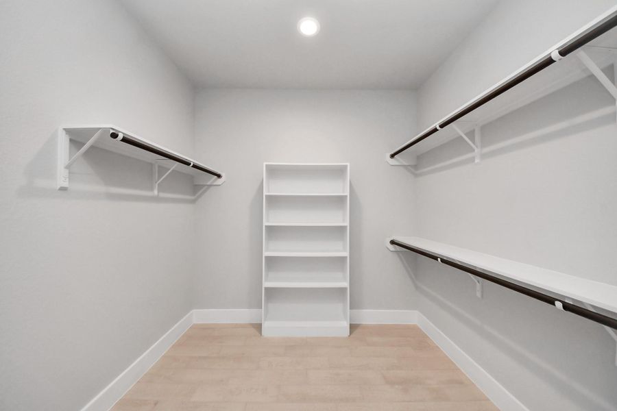 Walk-in closet that epitomizes luxury and practicality. This generously sized space features built-in shelving, offering abundant room for impeccable organization. High ceilings and recessed lighting create a bright and welcoming ambiance. Walk-in closet that epitomizes luxury and practicality. This generously sized space features built-in shelving, offering abundant room for impeccable organization. High ceilings and recessed lighting create a bright and welcoming ambiance.
