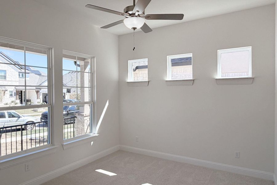 Unfurnished room with healthy amount of natural light, light carpet, and ceiling fan