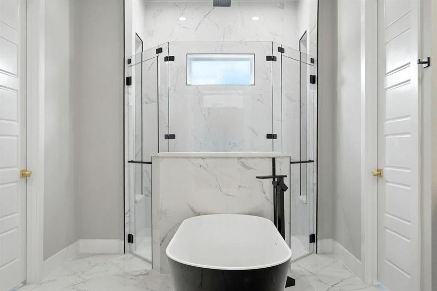 Full bath with a marble finish shower, a freestanding bath, and light marble finish floors