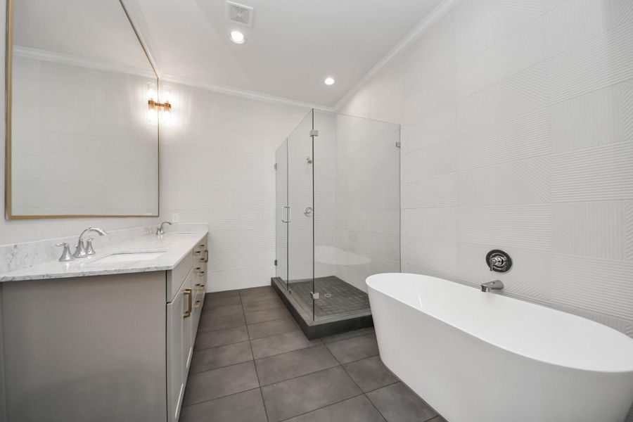 Freestanding soaking tub and frameless glass shower in the primary bath. Freestanding soaking tub and frameless glass shower in the primary bath.