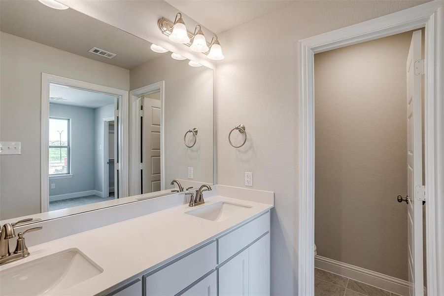 Bathroom with double vanity and baseboards