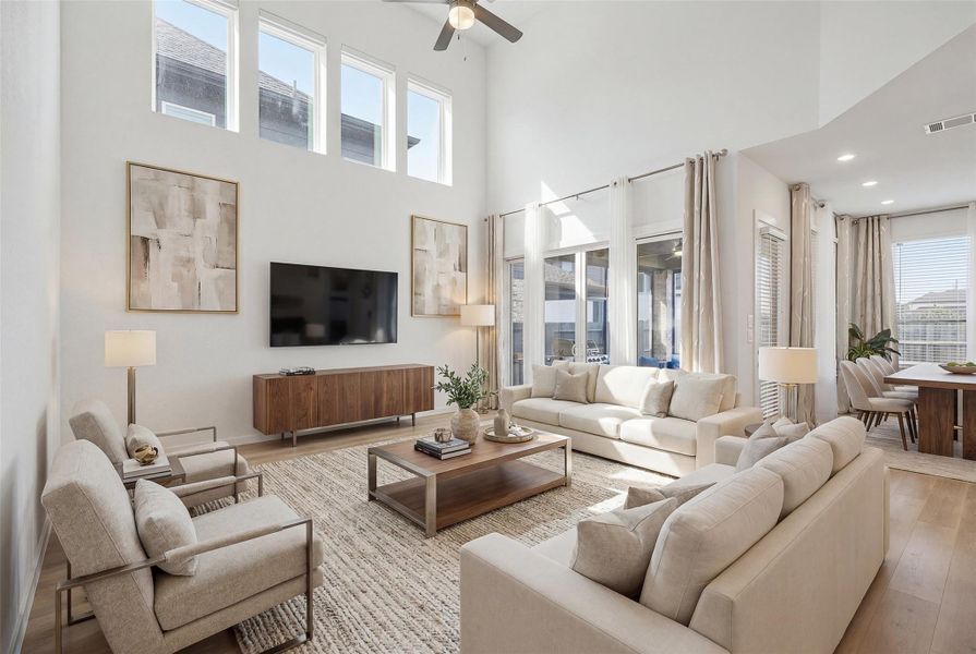 Enjoy a spacious living room featuring sleek wood flooring, sun filled windows, high ceilings, and a ceiling fan for year round comfort, along with direct access to the backyard perfect for effortless indoor-outdoor entertaining. *virtually staged