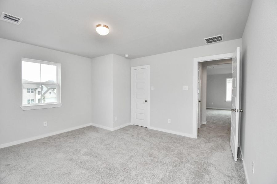 Generously sized secondary bedrooms featuring spacious closets, soft and inviting carpeting underfoot, large windows allowing plenty of natural light, and the added touch of privacy blinds for your personal retreat. Sample photo of completed home with similar floor plan. Actual colors and selections may vary.