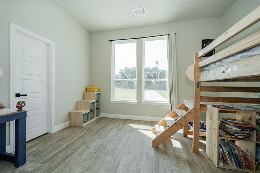 Bedroom featuring light wood-type flooring and baseboards Bedroom featuring light wood-type flooring and baseboards