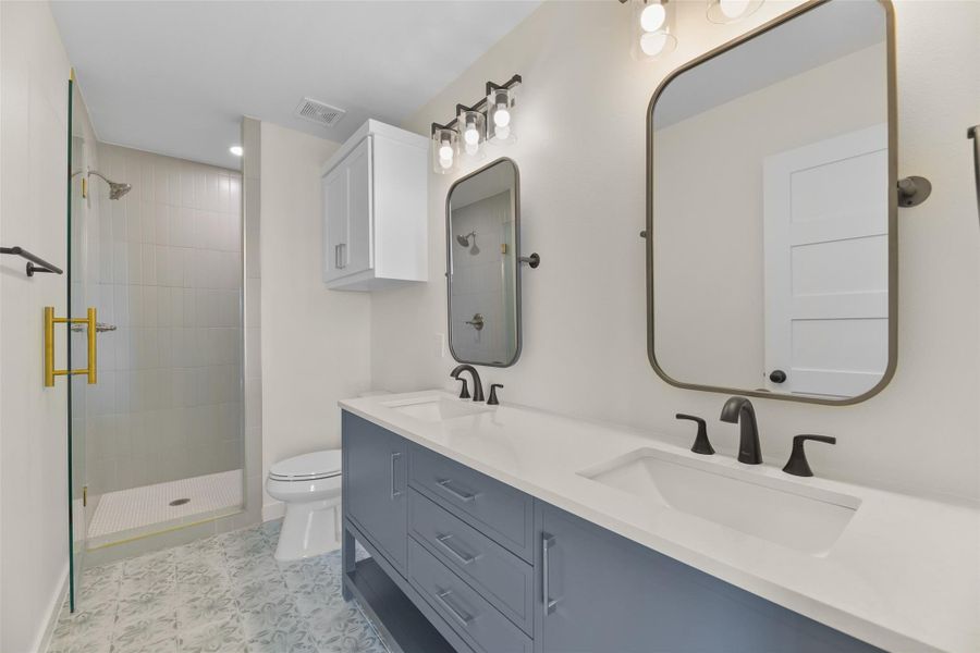 The double vanity and walk-in shower have custom tile work. The double vanity and walk-in shower have custom tile work.