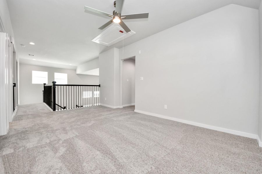 Come upstairs and enjoy a day of leisure in this fabulous game room! This is the perfect hangout spot or adult game room! Features plush carpet, high ceilings, custom paint and windows for plenty of natural light. Sample photo of completed home with similar floor plan. Actual colors and selections may vary.