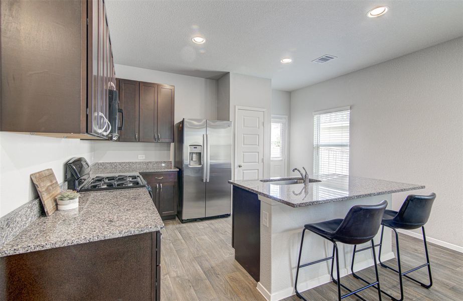 Granite counters and stainless steel appliances outfit this kitchen with an inviting island and sink. Granite counters and stainless steel appliances outfit this kitchen with an inviting island and sink.