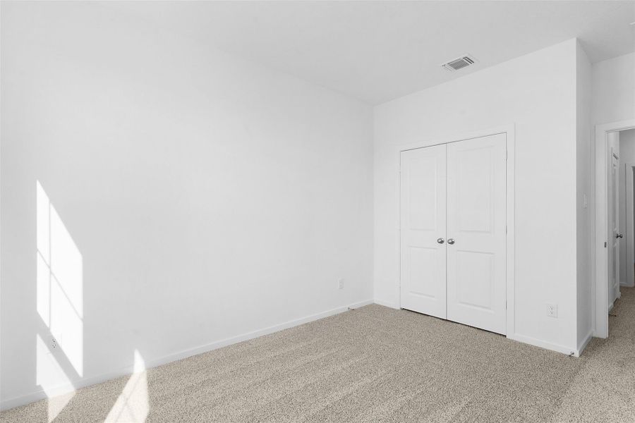 Unfurnished bedroom featuring carpet flooring and a closet Unfurnished bedroom featuring carpet flooring and a closet