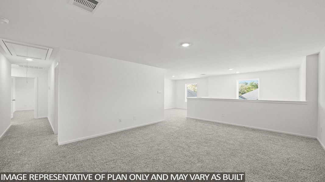 Empty room featuring attic access and light carpet