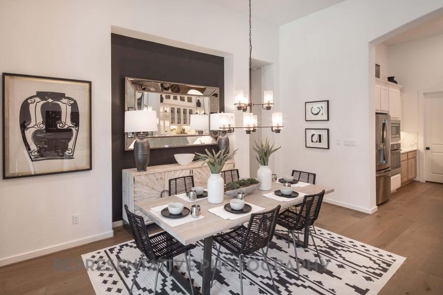 Dining area with a chandelier, wood finished floors, and baseboards Dining area with a chandelier, wood finished floors, and baseboards