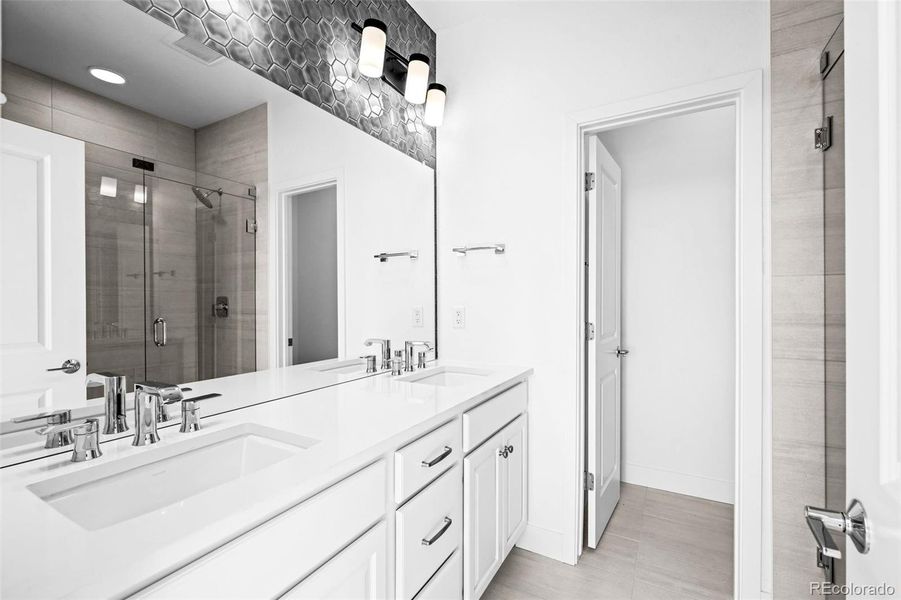 Primary ensuite with upgraded fixtures, tile, and frameless Euro shower.