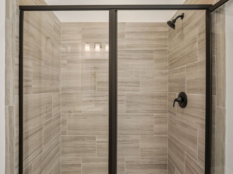 The primary bathroom offers dual vanity sinks and a walk-in shower.