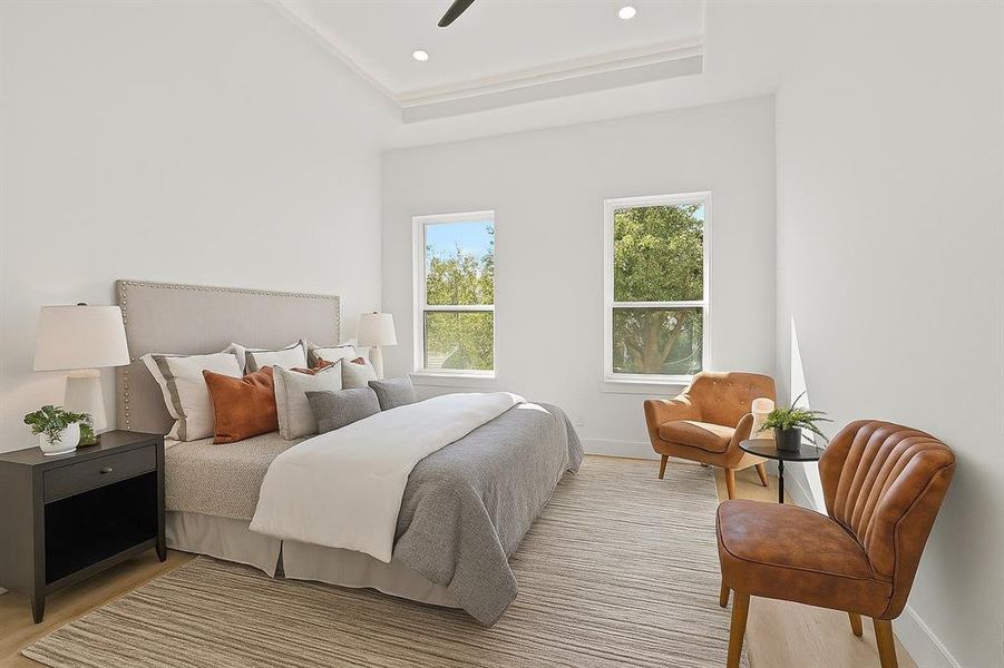 Digitally staged bedroom featuring a tray ceiling, a ceiling fan, and recessed lighting