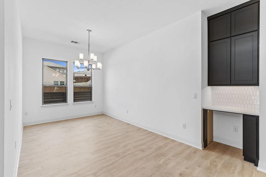 Unfurnished dining area featuring light wood-type flooring and a chandelier