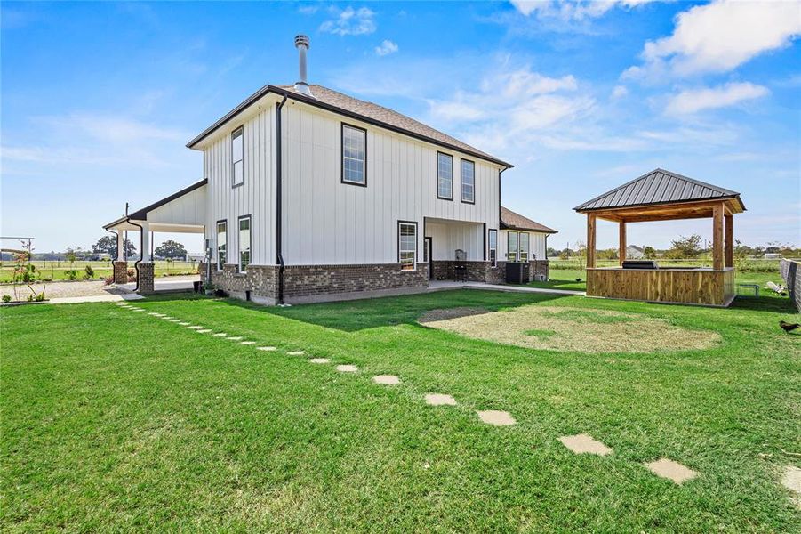 Back of property with brick siding, board and batten siding, a gazebo, and a patio Back of property with brick siding, board and batten siding, a gazebo, and a patio