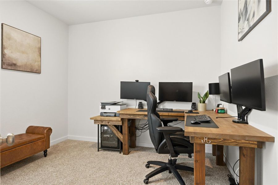 Office area featuring light carpet and baseboards