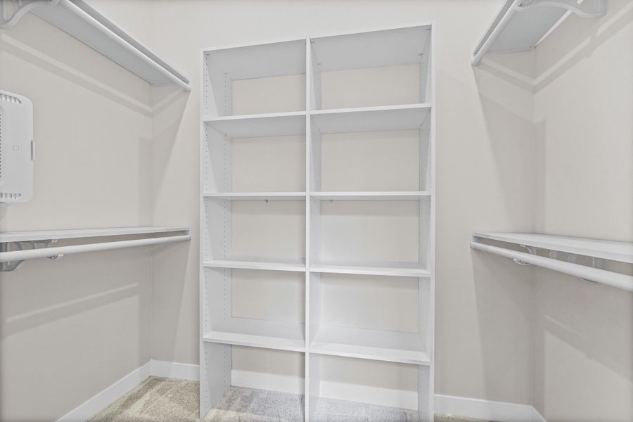 White closet system featuring extensive shelving and dual hanging rods White closet system featuring extensive shelving and dual hanging rods