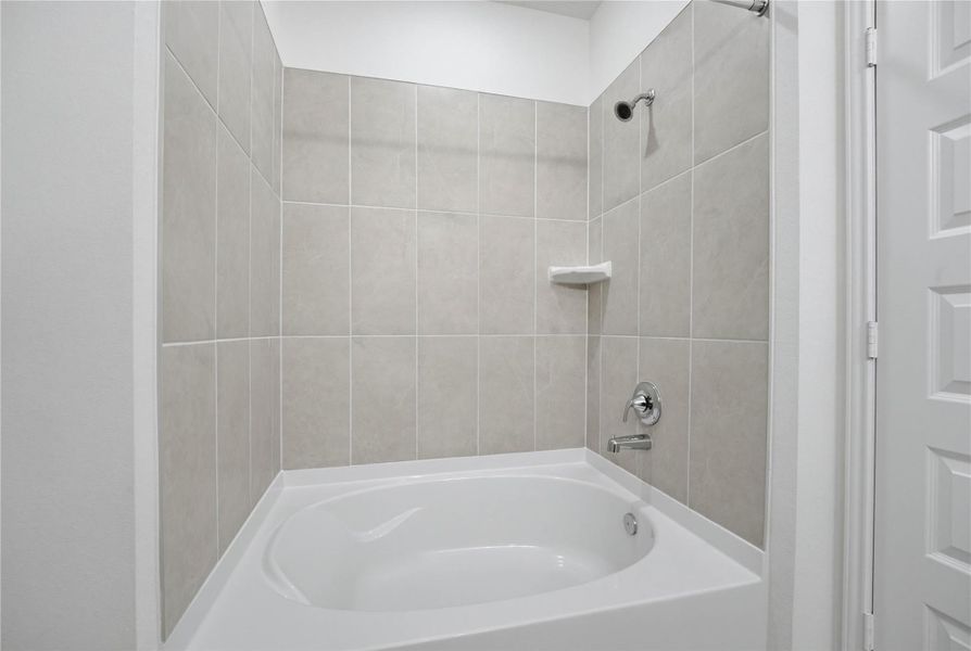 This view highlights the primary bathroom's versatile tub/shower combination, thoughtfully designed to accommodate both a quick, invigorating morning shower and a luxurious, deep soak after a long day.