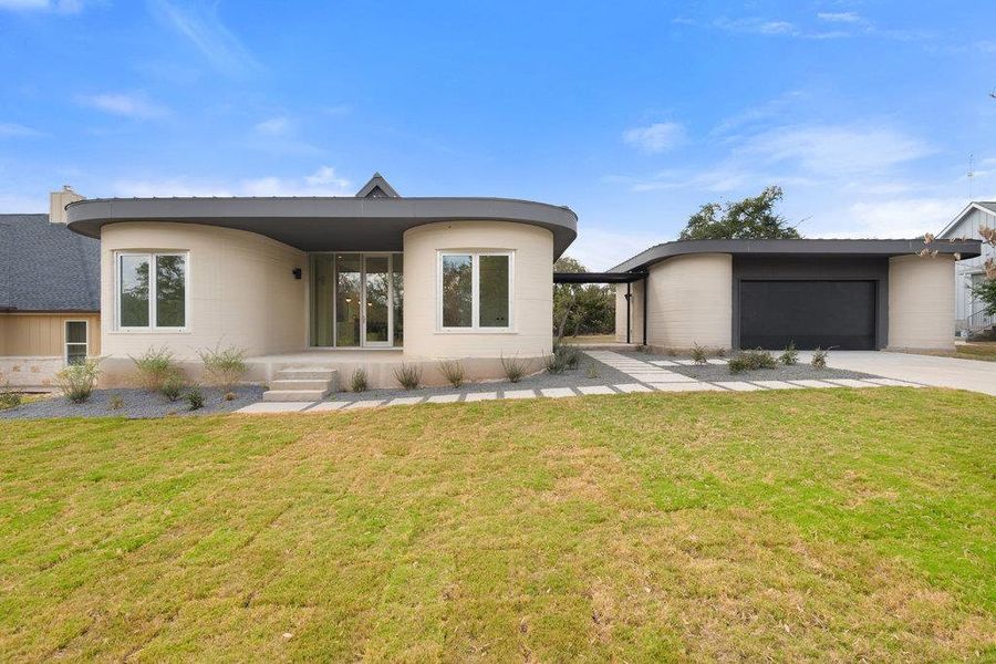 View of front facade with a front lawn, a garage, and driveway View of front facade with a front lawn, a garage, and driveway