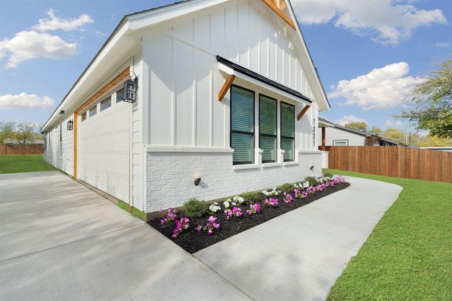 View of side of property with board and batten siding, brick siding, and a garage View of side of property with board and batten siding, brick siding, and a garage