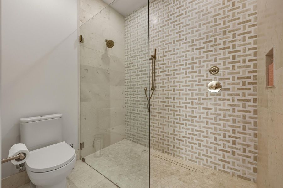 Travertine & dolomite tile with glass enclosure and linear tile