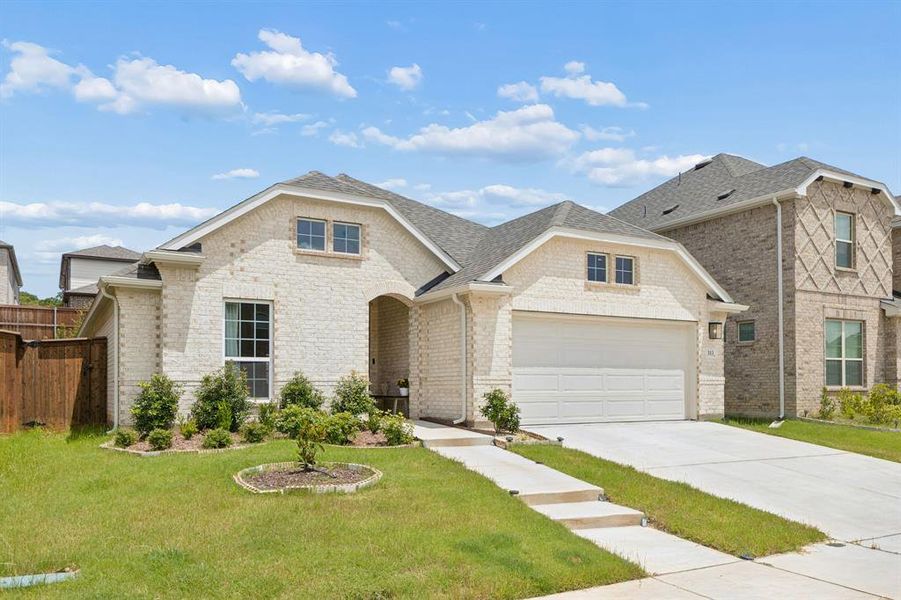 Contemporary single-story residence with a light-colored brick exterior, a two-car garage, and a covered entry