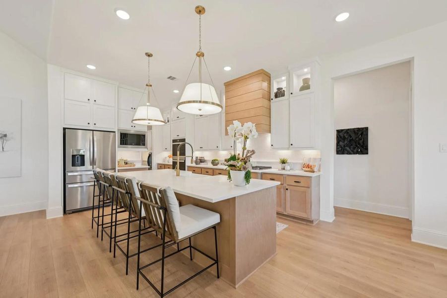 Culinary excellence awaits in this well-appointed kitchen, showcasing a large central island and gleaming hardwood floors. Culinary excellence awaits in this well-appointed kitchen, showcasing a large central island and gleaming hardwood floors.