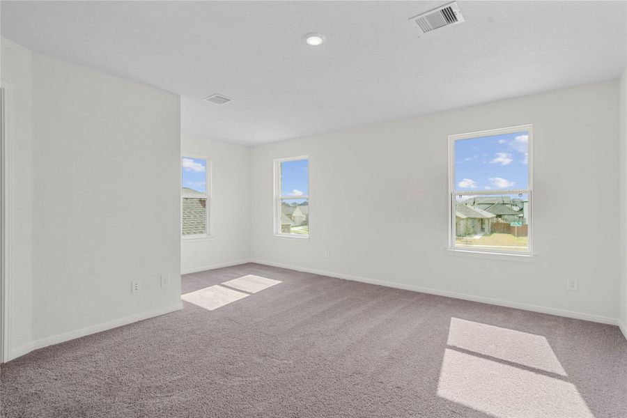 Relax and unwind after a long day in this impressive primary suite! This generously sized room offers plush carpeting, neutral-toned paint, high ceilings, recessed lighting, and large windows for added comfort and tranquility. Relax and unwind after a long day in this impressive primary suite! This generously sized room offers plush carpeting, neutral-toned paint, high ceilings, recessed lighting, and large windows for added comfort and tranquility.