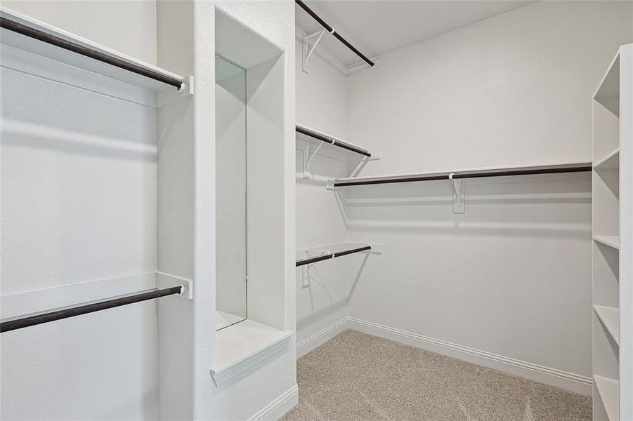 Walk in closet featuring light colored carpet