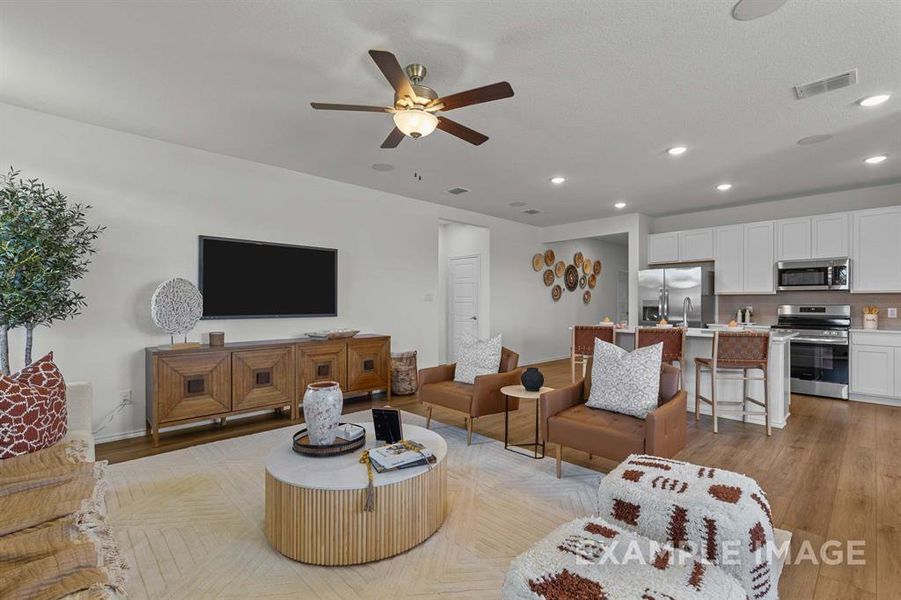 Living room with light hardwood / wood-style floors and ceiling fan