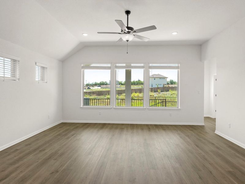 Spacious room featuring wood-finish flooring, vaulted ceiling, and recessed lighting