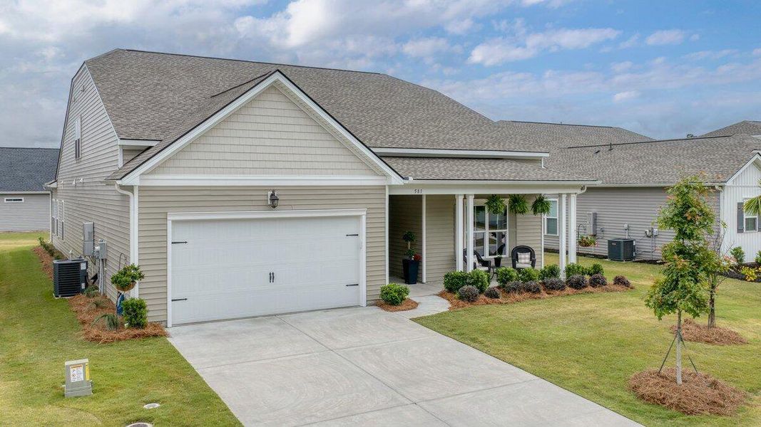Front exterior of a new home in K. Hovnanian's® Four Seasons at Lakes of Cane Bay, Summerville, SC, highlighting curb appeal (Image 24).