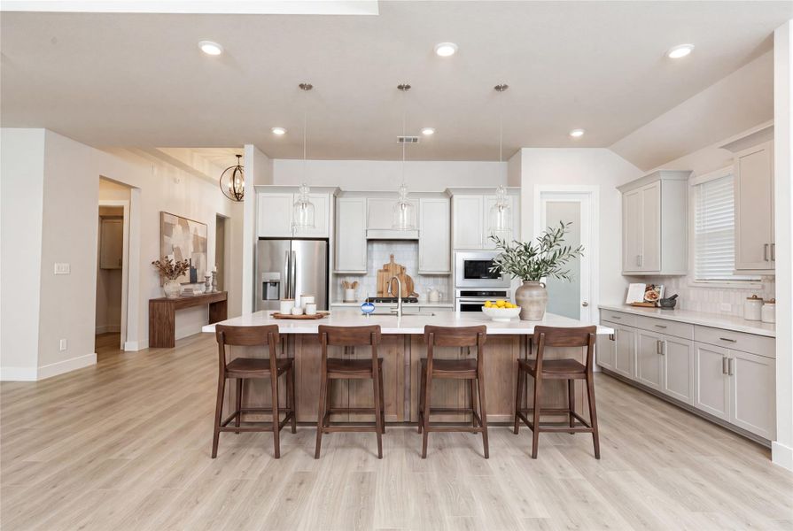 The stunning and generously sized center island features a breakfast bar, perfect for casual dining and entertaining. The island is beautifully designed with pristine quartz countertop and elegant pendant lights. *Virtually Staged. The stunning and generously sized center island features a breakfast bar, perfect for casual dining and entertaining. The island is beautifully designed with pristine quartz countertop and elegant pendant lights. *Virtually Staged.