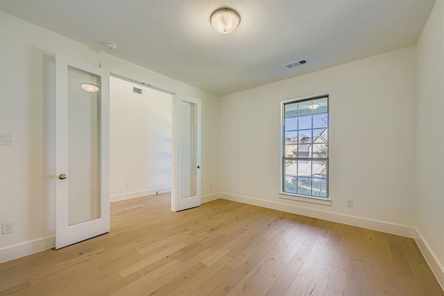 Spare room with light wood finished floors and baseboards Spare room with light wood finished floors and baseboards