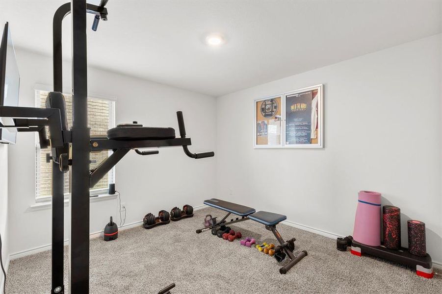 Exercise area with carpet flooring and baseboards