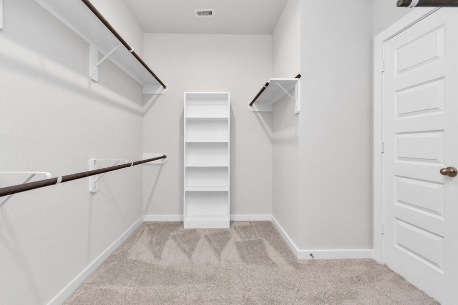 Immerse yourself in the lap of luxury within this roomy walk-in closet boasting high ceilings and plush carpeting. Sample photo of completed home with similar floor plan. Actual colors and selections may vary.