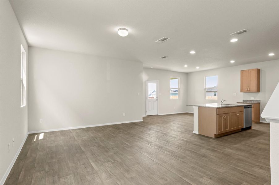 Kitchen with open floor plan, dishwasher, dark wood-style floors, recessed lighting, and light countertops
