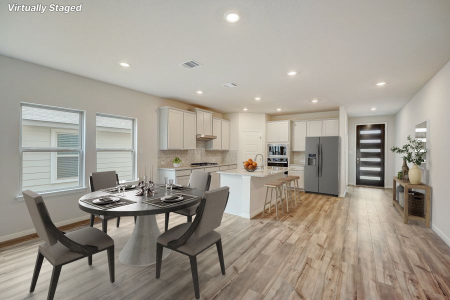 Virtually staged dining room and kitchen in the Pearl floorplan at a Meritage Homes community.