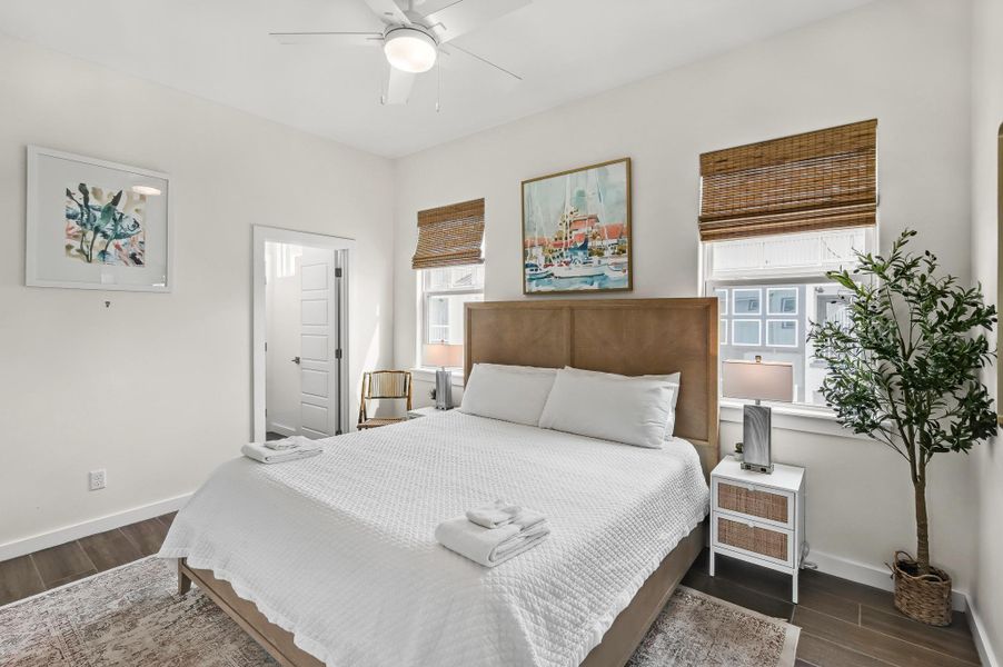 Bedroom with dark wood-type flooring and a ceiling fan Bedroom with dark wood-type flooring and a ceiling fan