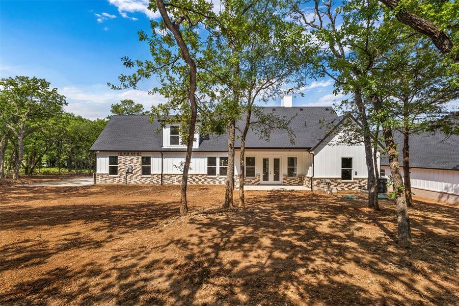 The property features a white exterior with brick accents, a dark roof, and multiple windows