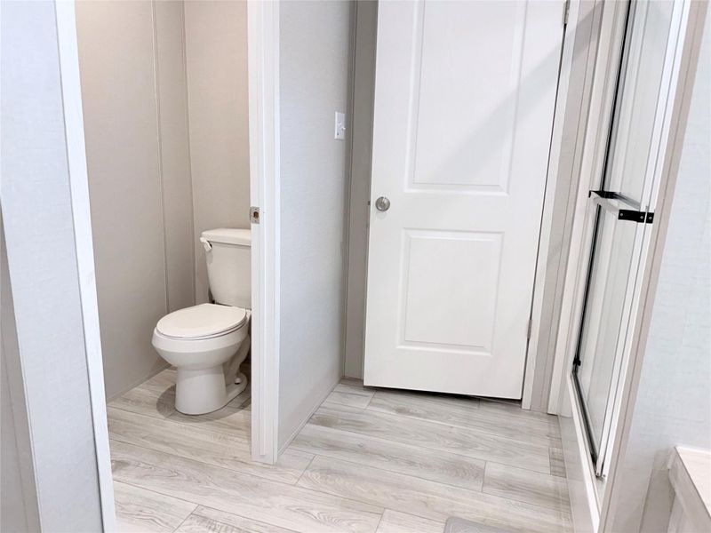 A well-appointed bathroom features a commode and light-toned flooring.