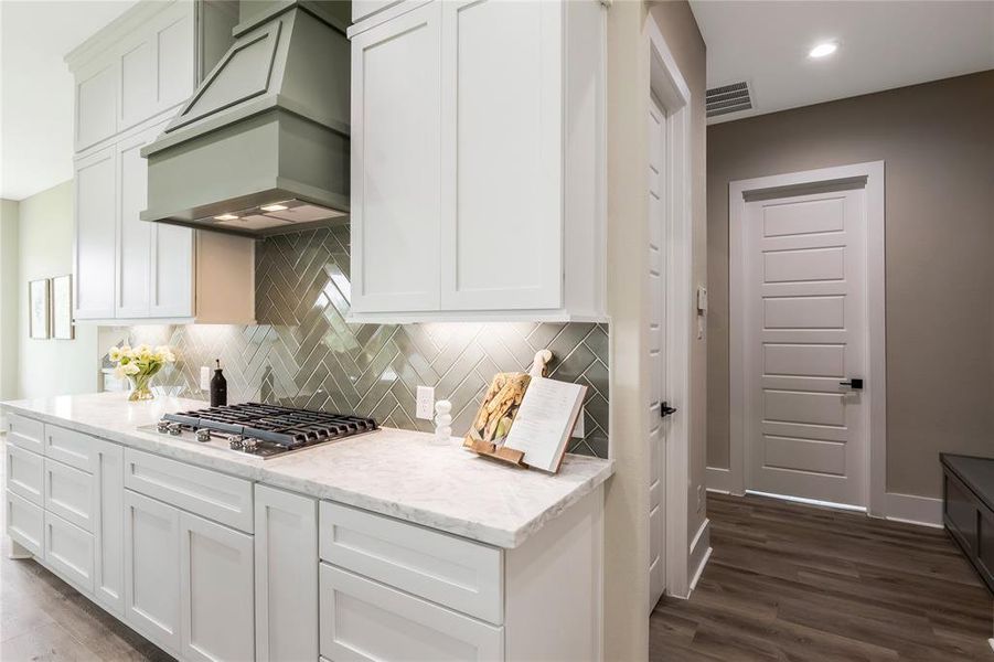 Stylish herringbone tile backsplash, and a clean marble countertop, it includes a built-in gas stovetop Stylish herringbone tile backsplash, and a clean marble countertop, it includes a built-in gas stovetop