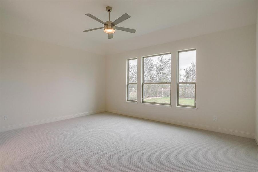 Carpeted spare room featuring ceiling fan