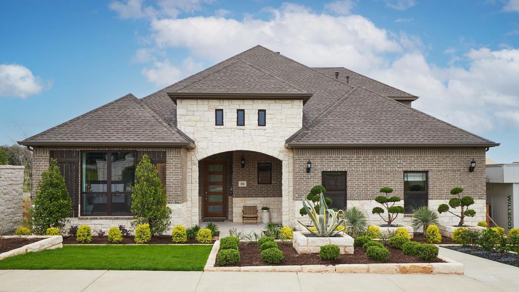 French country home with stone siding, a shingled roof, and brick siding French country home with stone siding, a shingled roof, and brick siding
