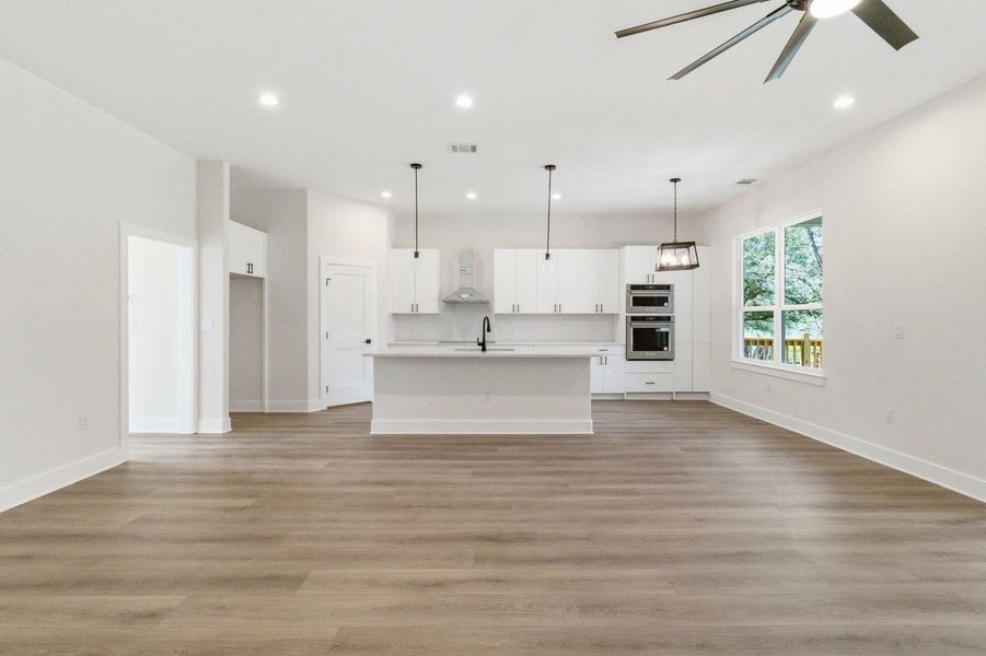 A contemporary kitchen and living area featuring sleek cabinetry and recessed lighting. A contemporary kitchen and living area featuring sleek cabinetry and recessed lighting.