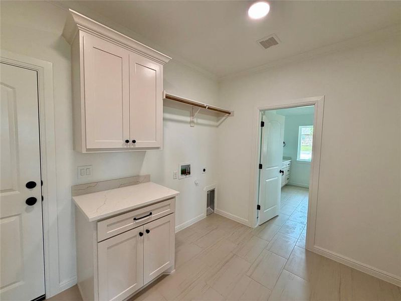 Laundry area featuring white shaker-style cabinetry, a light-toned countertop, wood-finish flooring, a wall-mounted clothes rod, and a recessed ceiling light