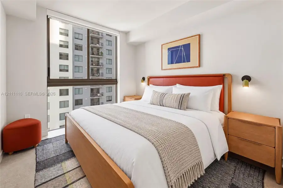 Floor-to-ceiling windows with dark metal framing and wall-mounted metallic sconces